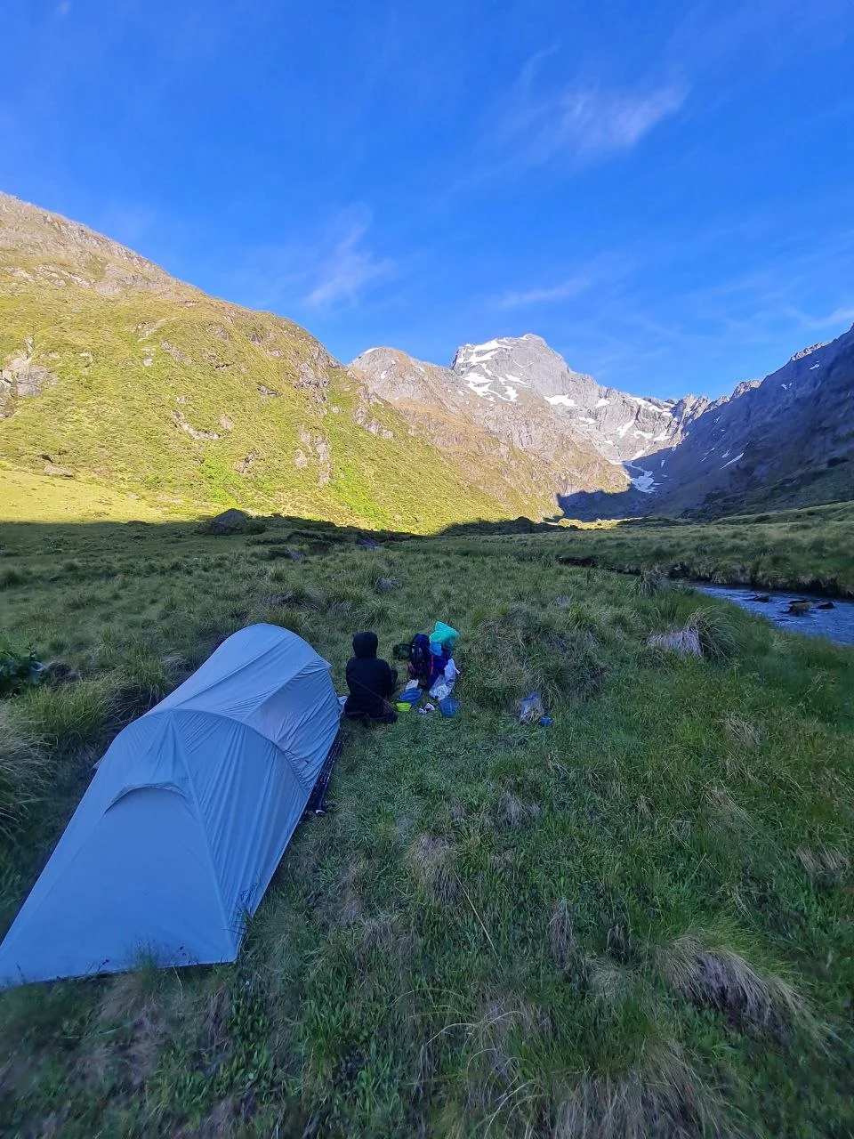 Campsite in the Siberia Valley, tent beside a side stream, steep mountain walls.