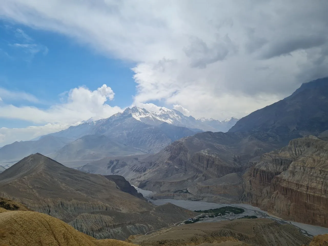 Arid Mustang valley carved by the Kali Gandaki River, snow peaks beyond.