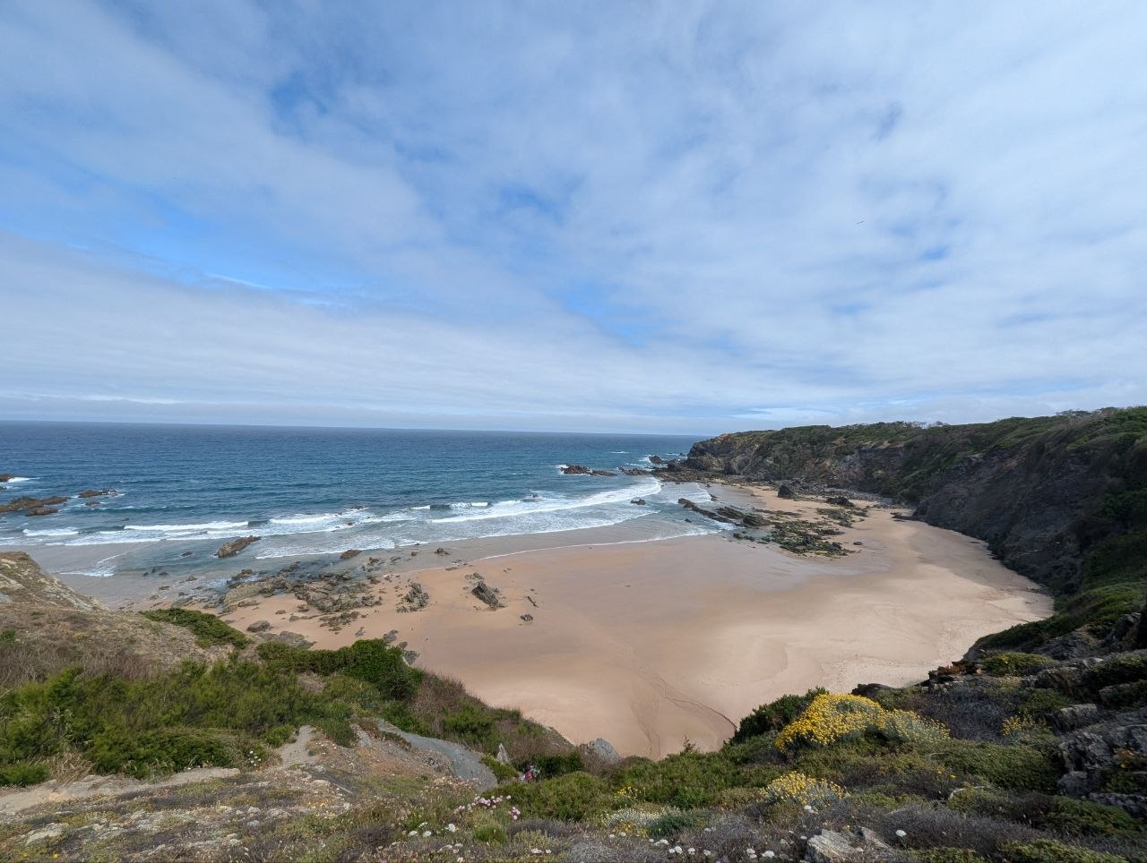 Coastal view of sandy cove and rocky cliffs