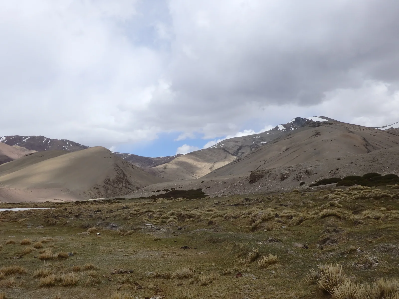 Sand dune ridges rising up the arid mountain flanks above alpine turf in the Kyamar valley.