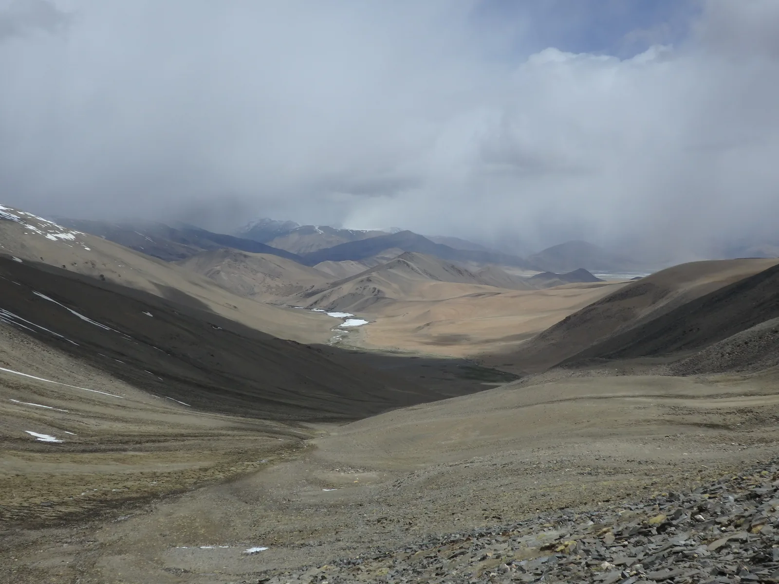Looking down into the vast, shadow-swept desert valley of Gyama Loma from the pass descent.