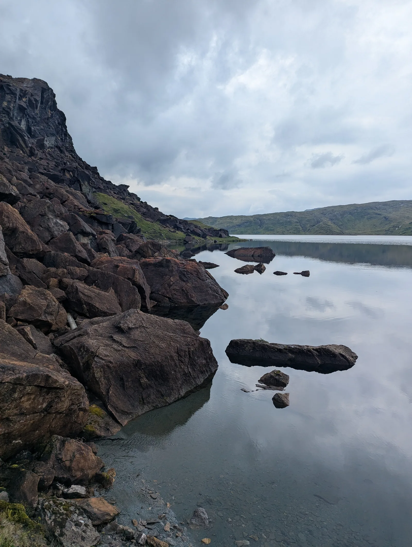 Following the rocky shoreline along a mountain lake at 874 m on Day 6 between Åsedalen and Selhamar.