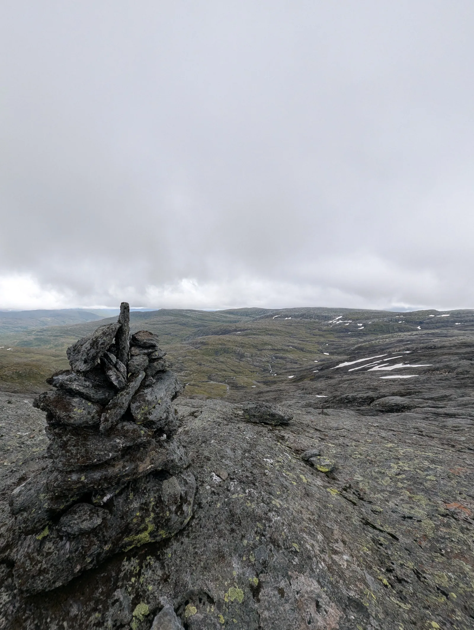 A traditional DNT stone cairn (varde) marking the trail across barren granite fells at 1,156 m between Torvedalshytta and Volahytta (Day 8).