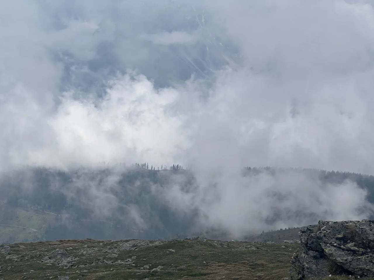 Low clouds swallow the forested ridges below Bonner Hut on the Stoneman Dolomiti route.